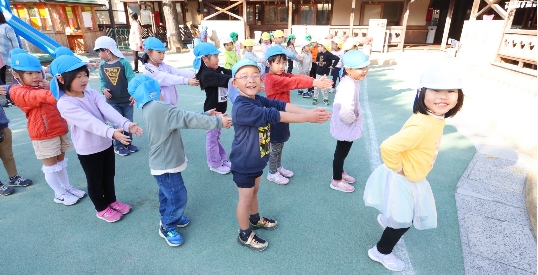 笑顔で前ならえをする園児たち